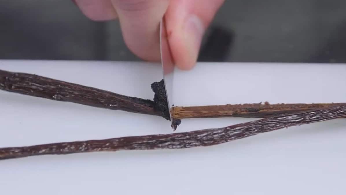 Chef qui gratte une gousse de vanille fendue NOROHY